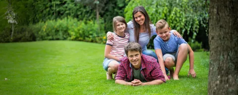 family laying in grass